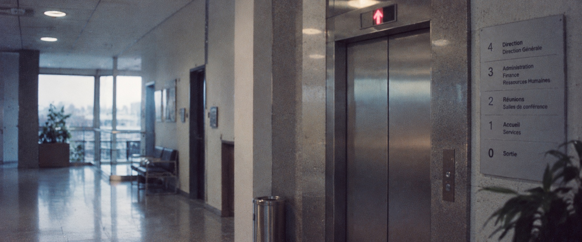 Couloir de bureau avec ascenseur et panneau de direction